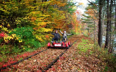 A couple pedals underneath the fall foliage beside the Esopus Creek in The Catskills Division