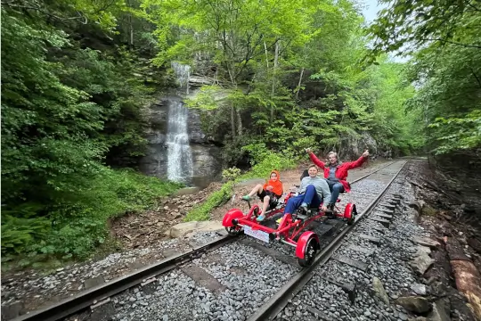 A group pedals into the forest, with the river on one side and the mighty rockfaces on the other.