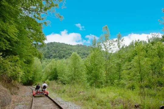 A group kicks off the tour, headed into the mountains below. An open blue sky welcomes them.