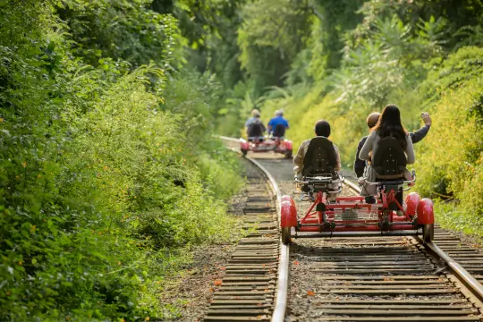 A group waves to the camera as they cross over a small but historic stone bridge.
